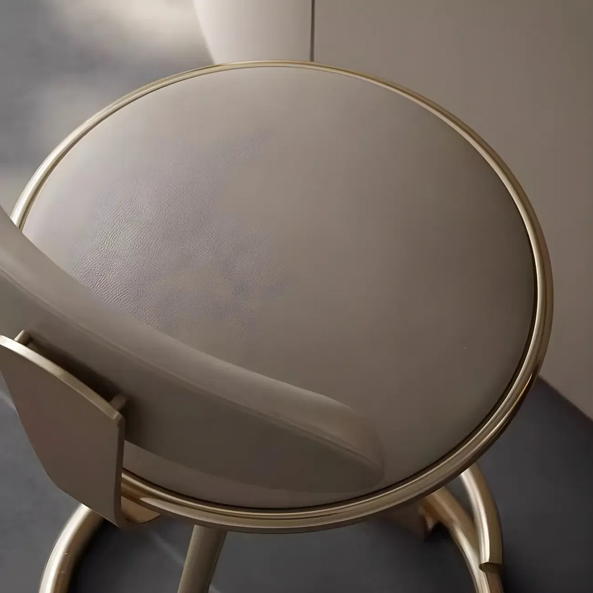 Luxe barkruk met strak beige leer en een goudkleurig metalen frame
